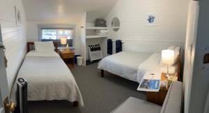 a small room with two beds and a table with lamps at Tofino Paddlers Inn in Tofino