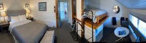 a small bedroom with a bed and a television in it at Tofino Paddlers Inn in Tofino