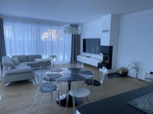 een woonkamer met een bank, een tafel en stoelen bij Bungalow KONI in Annaberg im Lammertal