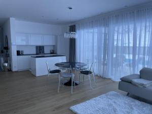 een keuken en woonkamer met een tafel en stoelen bij Bungalow KONI in Annaberg im Lammertal