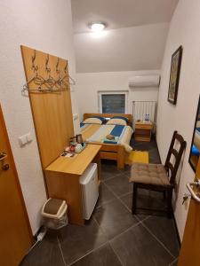 a small bedroom with a bed and a desk and a table at Villa Hukic in Tuzla