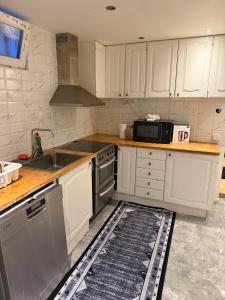 una cucina con mobili bianchi, un lavello e un microonde di Amazing cozy apartment 