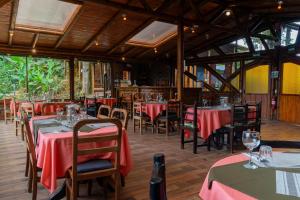 un restaurant avec des tables et des chaises avec une nappe rouge dans l'établissement Bellavista Cloud Forest Lodge & Private Protected Area, à Tandayapa