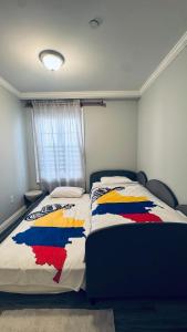 a bedroom with a bed with a colorful blanket at Explore Rooms JFK in Locust Manor