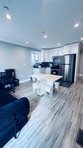 a living room with a table and a kitchen at Explore Rooms JFK in Locust Manor