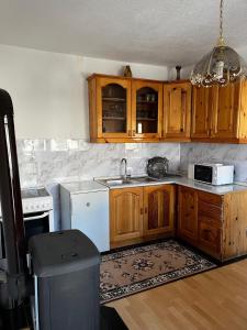 een keuken met houten kasten en een wit apparaat bij Apartman Marija in Kupres