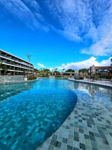 a swimming pool with blue water in a resort at Luxuoso e sofisticado Beach Class Verano by HM in Ipojuca