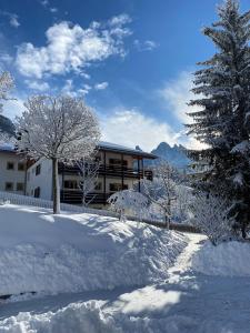 una casa ricoperta di neve con alberi di fronte di MiraOdle Apartments a Villnoss