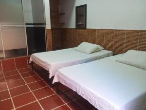 two beds sitting next to each other in a room at Hotel KAMELLON in Estación El Salto +5 photos