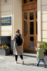 a woman and a child walking in front of a door at SERENITY Aparthotels - Old Town Poznan by Friendly Apartments in Poznań