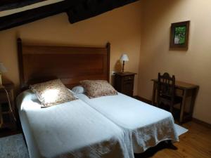 a bedroom with a large white bed with two pillows at Casona de Gómez y Terán in Renedo