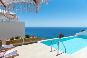 a swimming pool with the ocean in the background at Althea Anafi Suites in Anafi