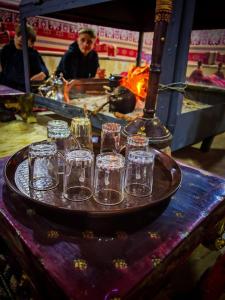 a group of glasses on a tray on a table at Desert Elegance Luxury Bedouin Camp Panoramic View in Disah
