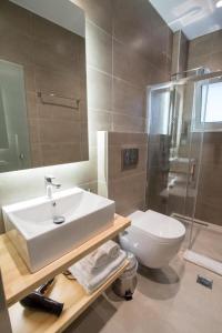 ein Badezimmer mit Waschbecken, Toilette und Dusche in der Unterkunft Preveza Rooms in Preveza