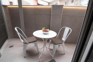 einen Tisch und zwei Stühle mit einer Obstschale darauf in der Unterkunft Preveza Rooms in Preveza