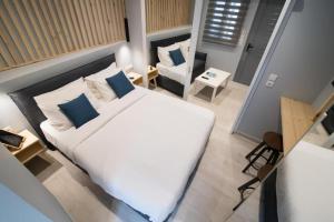 a bedroom with a large white bed and a chair at Preveza Central Stay in Preveza