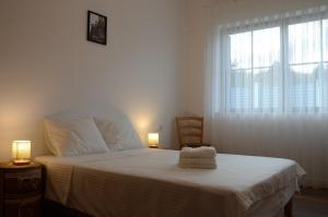 een slaapkamer met een bed met witte lakens en een raam bij Vila Bella in Oradea