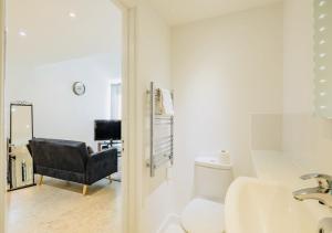 a bathroom with a sink and a toilet and a chair at Riverlight Studio sleep 3 in Cambridge