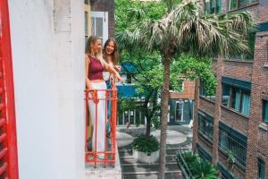 two women standing on the balcony of a building at Mad Monkey Potts Point in Sydney