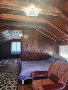 a bedroom with a bed and a couch in a room at Cabana Maria in Olăreşti