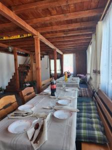 a long table with plates and napkins on it at Cabana Maria in Olăreşti