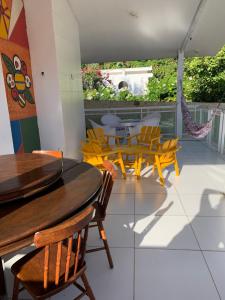 a dining room with yellow chairs and a table at Casa de praia ampla e reformada in Japaratinga