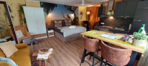 ein Wohnzimmer mit einem Bett und einem Schreibtisch mit Stühlen in der Unterkunft Gästehaus Köhler in Waldsolms