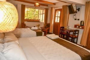 una camera d'albergo con due letti e una televisione di Hotel Boutique MIRANDO AL SOL a Ollantaytambo