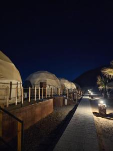 a row of tents in the desert at night at Ajyad Rum Camp in Wadi Rum