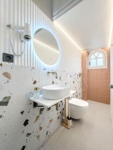 a bathroom with a sink and a toilet and a mirror at Preveza Central Stay in Preveza