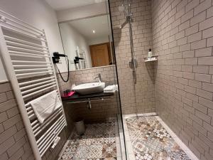 een badkamer met een douche met wastafel en spiegel bij Landhotel Lindenhof in Feld am See +56 foto's