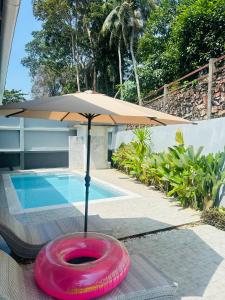 a pink frisbee sitting on a table next to a pool at Aonang Peace Pool Villa in Ban Khlong Haeng