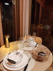 a table with white plates and wine glasses on it at Petit chalet indépendant 2 pers "La cabane de Jean " in Briançon +29 photos
