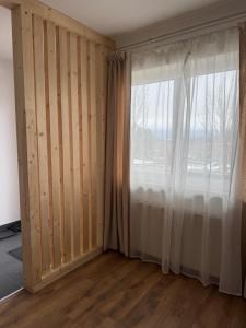 een kamer met een groot raam en een gordijn bij Wohnung Magdalene in Größing