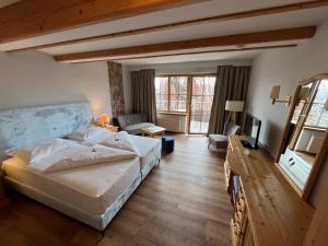 een slaapkamer met een bed en een woonkamer bij Landhotel Lindenhof in Feld am See