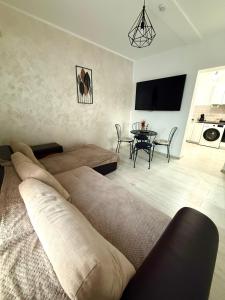 een woonkamer met een bed en een tafel bij Cleo Residence 3 Ghiroda in Ghiroda +16 foto's