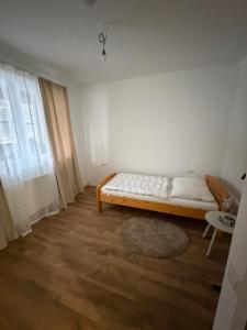 een witte kamer met een bed en een tapijt bij Wohnung Magdalene in Größing