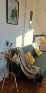 a living room with a green couch with a blanket on it at Cozy and fully equipped flat in the centrum in Essen