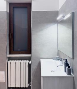 een badkamer met een wastafel, een spiegel en een radiator bij DalGra room e garden in Torrevecchia Teatina +41 foto's