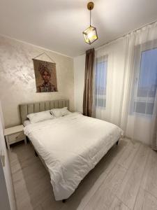 een slaapkamer met een groot wit bed. bij Cleo Residence 4 Ghiroda in Ghiroda