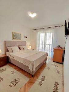 een slaapkamer met een groot bed en een televisie bij Apartment Maruni in Šušanj +16 foto's