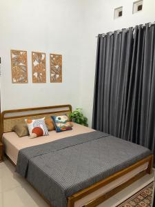 een slaapkamer met een bed met een zwart gordijn bij Wening Stay in Srondolwetan