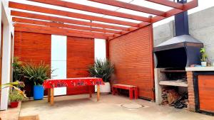 a patio with a red bench and a fireplace at Casa en Concon in Vina del Mar
