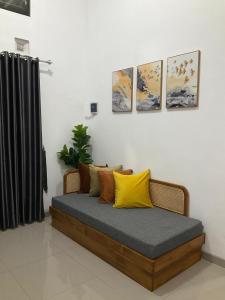 een bed met gele kussens in een kamer bij Wening Stay in Srondolwetan