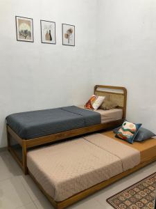 twee bedden naast elkaar in een kamer bij Wening Stay in Srondolwetan