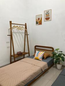 een slaapkamer met 2 bedden en een plant bij Wening Stay in Srondolwetan