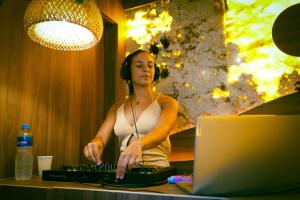 a woman wearing headphones standing in front of a computer at Leblon Beach Hostel in Rio de Janeiro