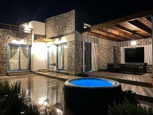 a large room with a swimming pool at night at Anasa Rustic Villa in Kolymbia