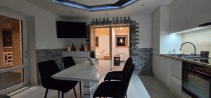 a dining room with a white table and black chairs at Apartament u Krupy z Prywatnym Jacuzzi i tarasem Widokowym in Murzasichle