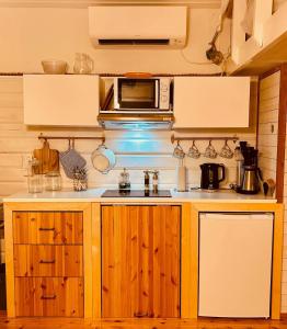 a kitchen with wooden cabinets and a microwave at Kaj's Cabin in Listerby +6 photos